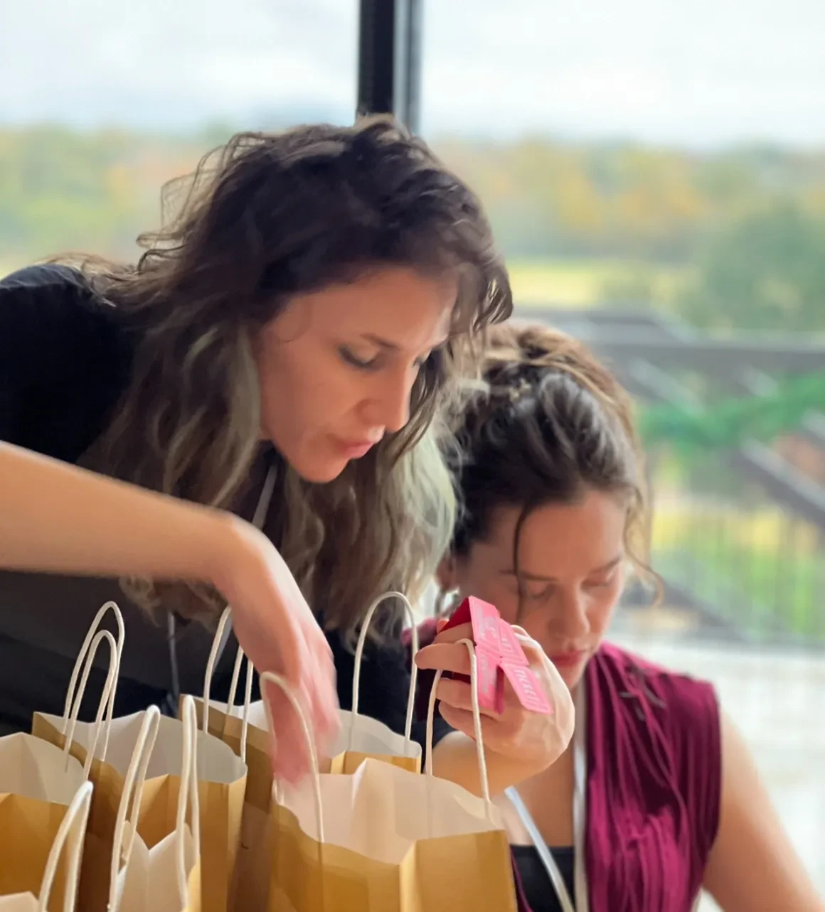 Women preparing gift bags at event