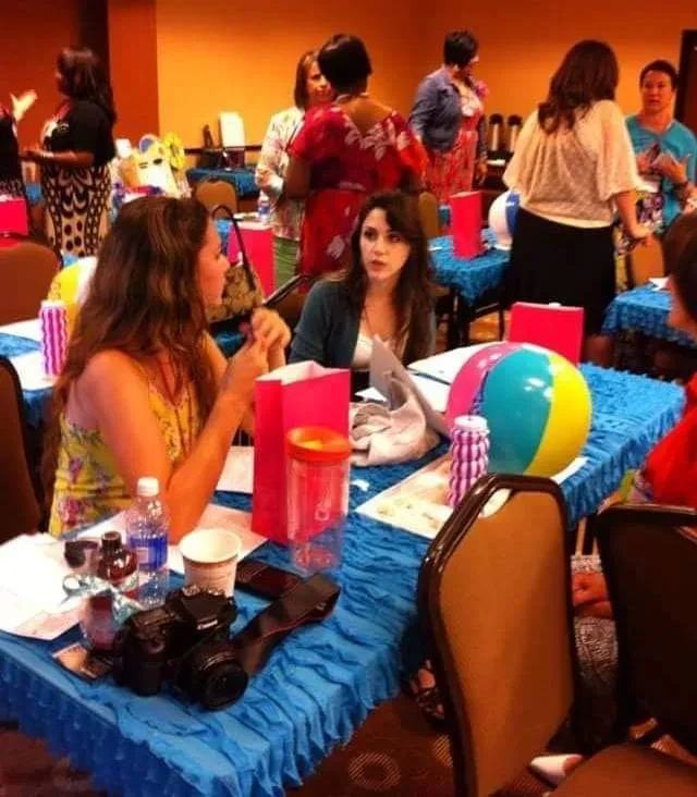Women networking at colorful event with beach ball decorations